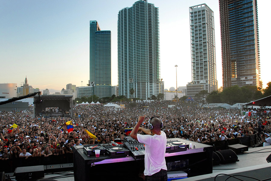 DJ performing on stage at Ultra Music Festival in Miami in front of a huge, energetic crowd of attendees.