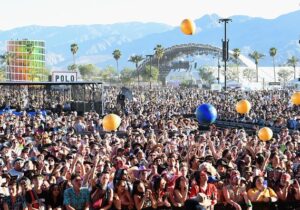 Massive crowd cheering on performers at Coachella music festival.
